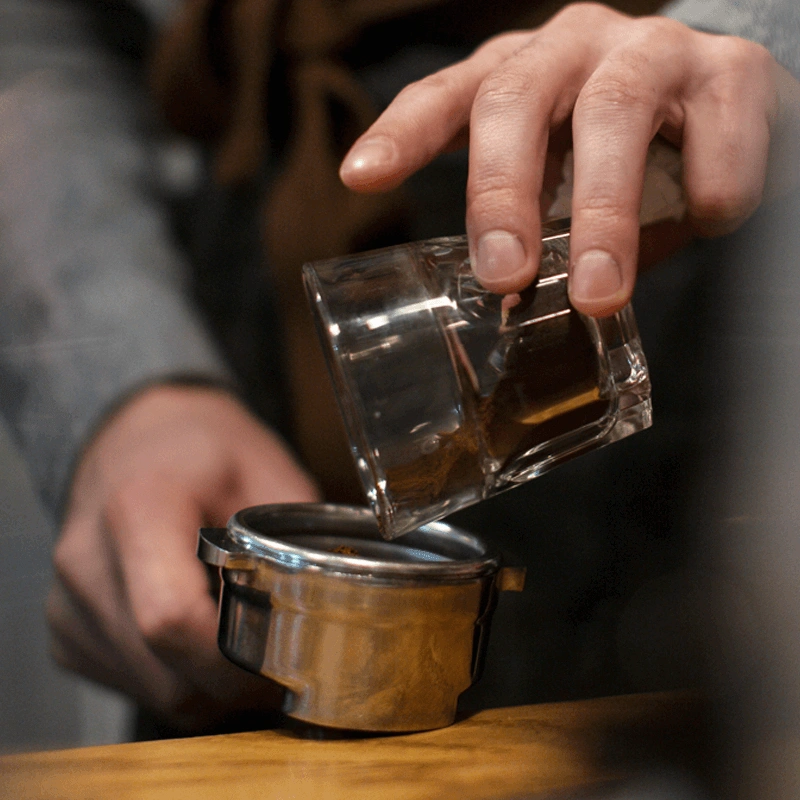 Man poring coffee into a barrister machine