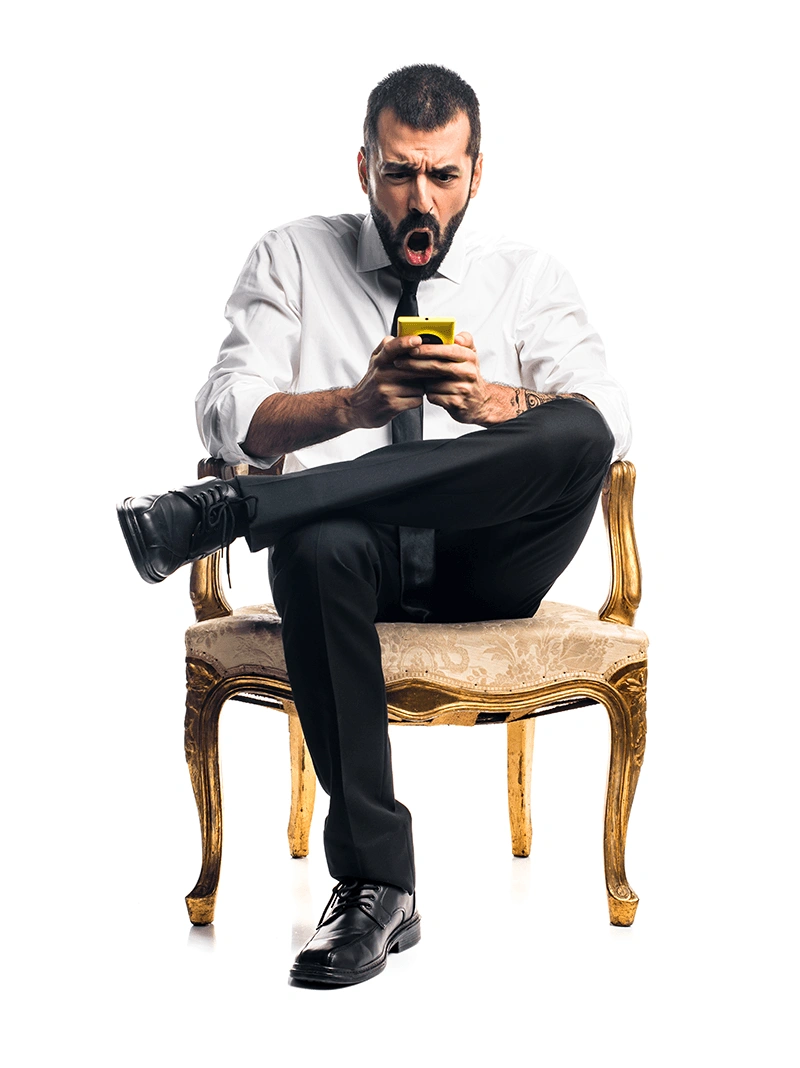 Man sitting on a chair looking amazed at his mobile phone